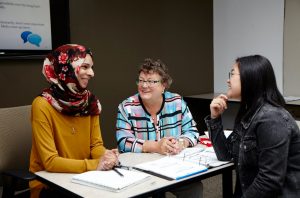 Adult learners having a discussion at a table in class